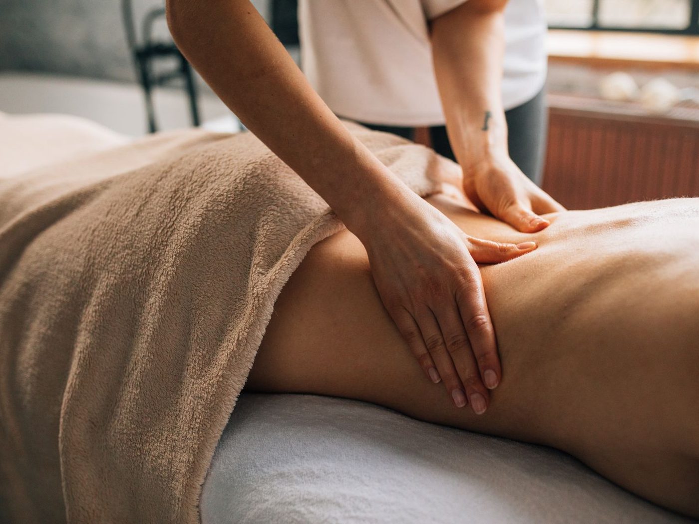 A draped client on the massage table during a full-body session